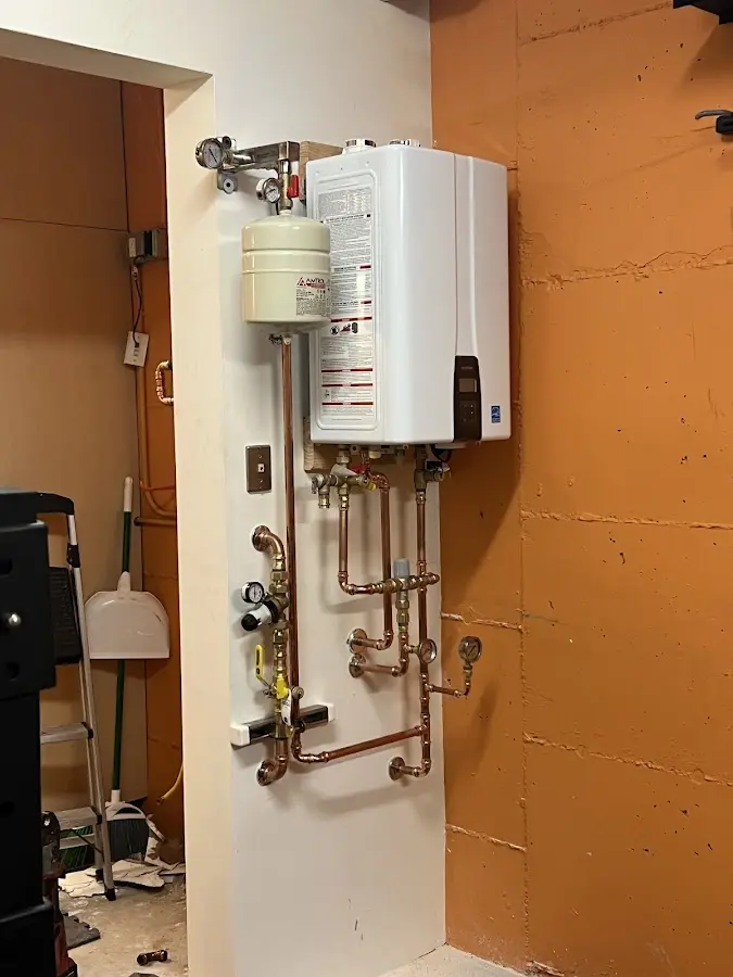 Plumbing technician inspecting water heater connections in Robertsdale